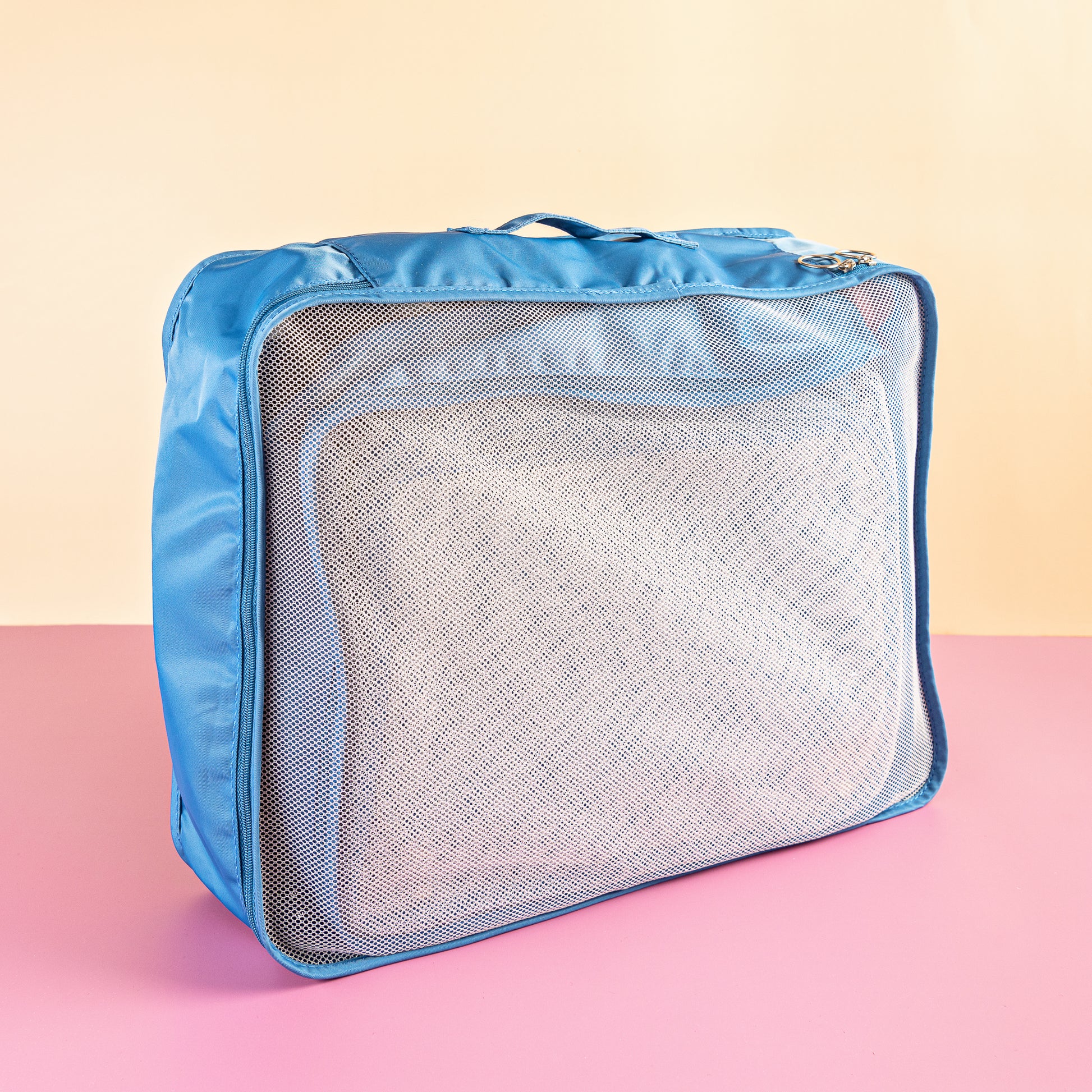blue packing cubes on a pink and yellow background