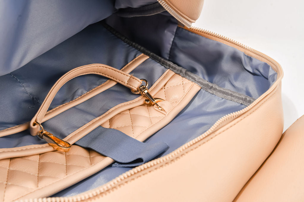 beige backpack opened up on a white background