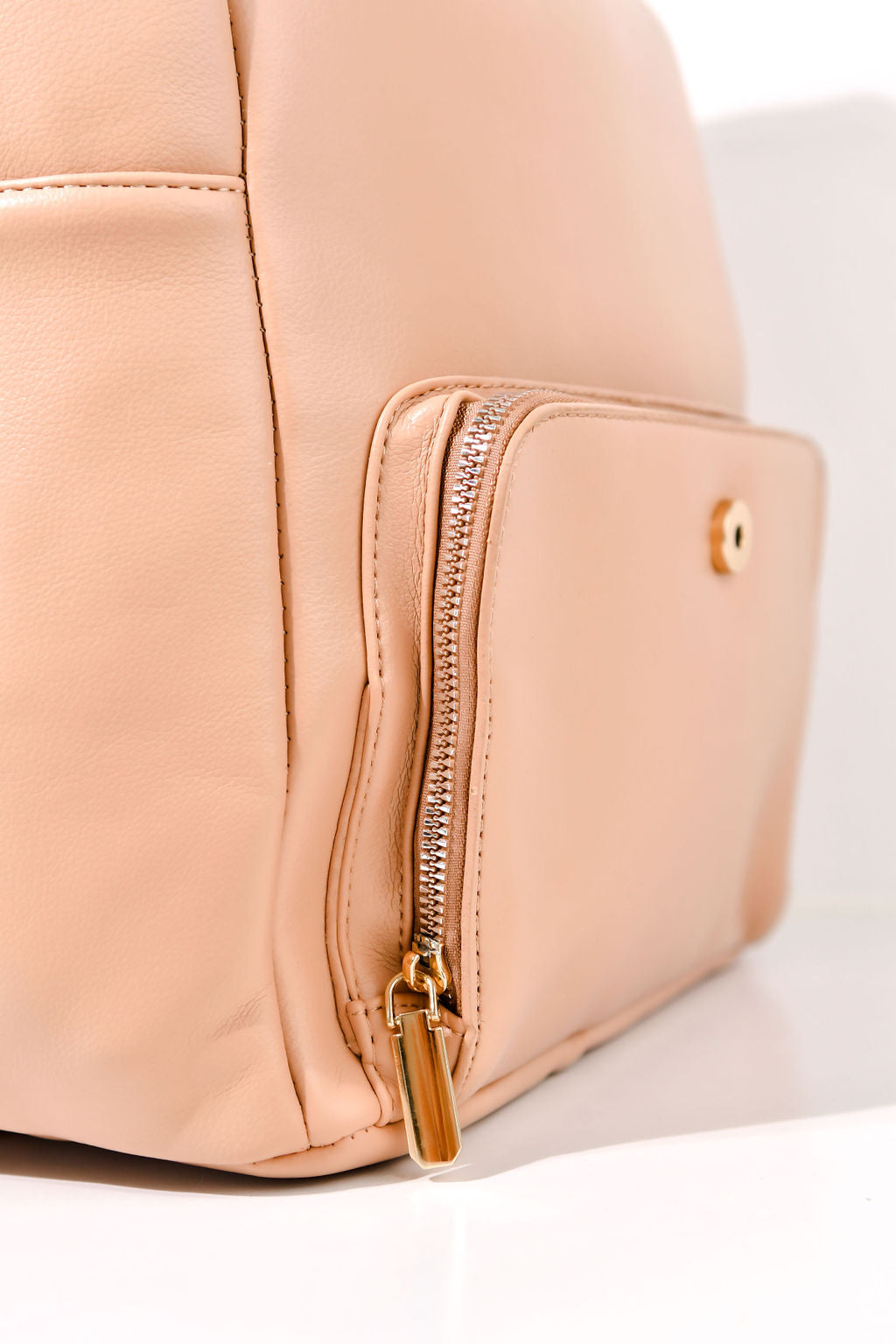 tan backpack front pocket on a white background