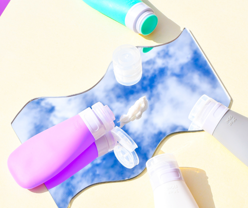 90ml travel bottles on a yellow background with a mirror reflecting clouds on it.