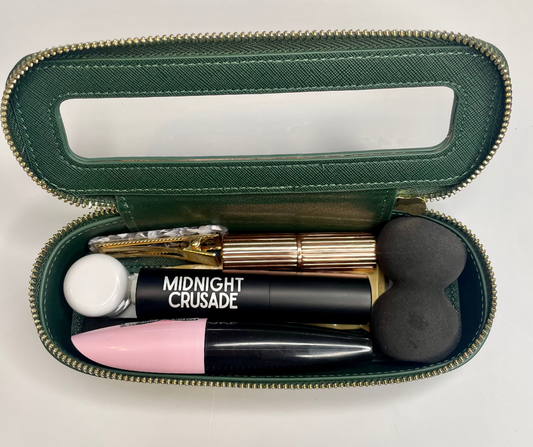 green mini cosmetic case with cosmetics inside on a white background