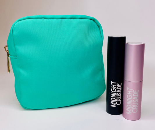 green mini cosmetic case/ handbag organiser on a white background with travel atomisers sitting next to it