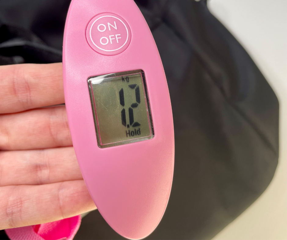 pink luggage scale showing a weight on the screen