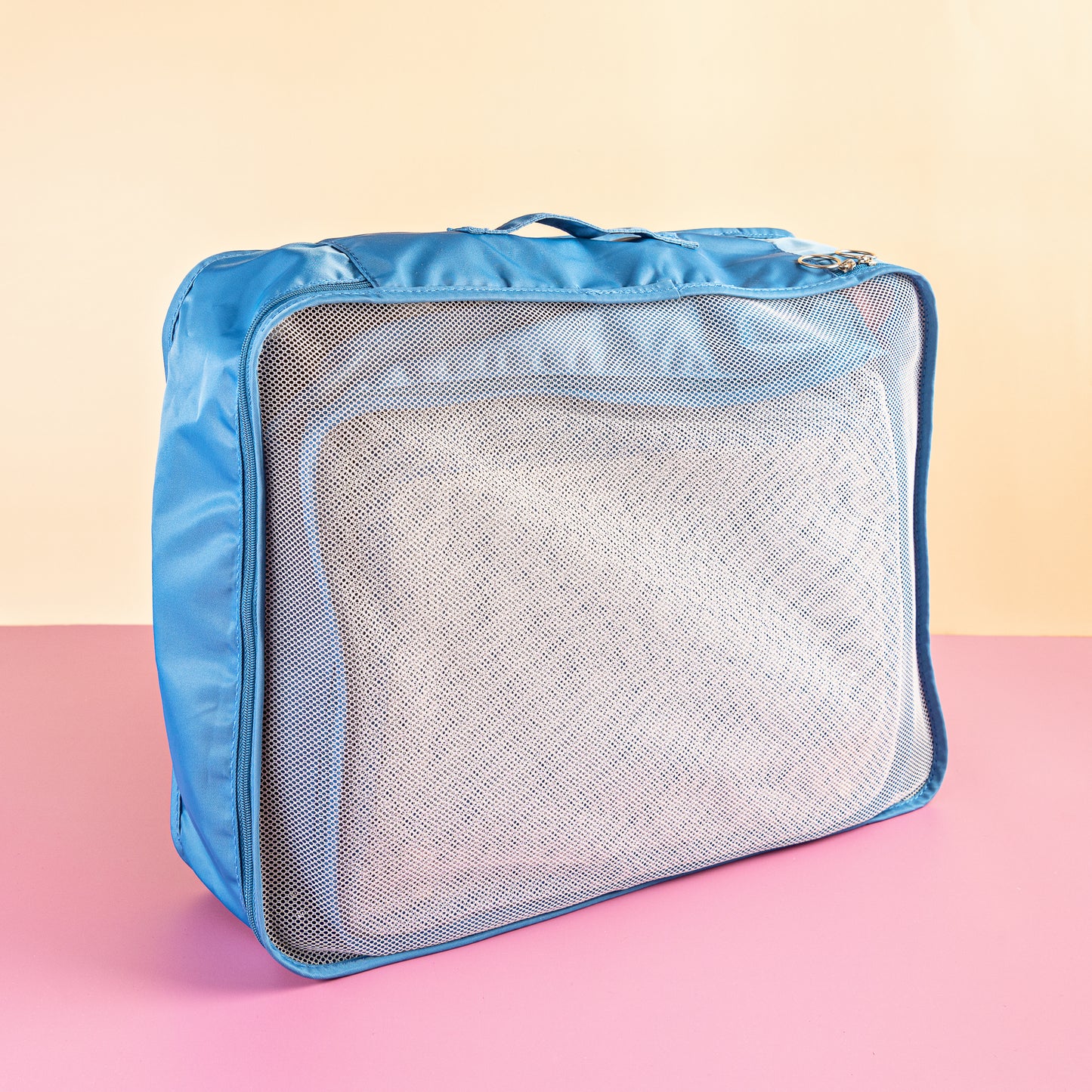 blue packing cubes on a pink and yellow background
