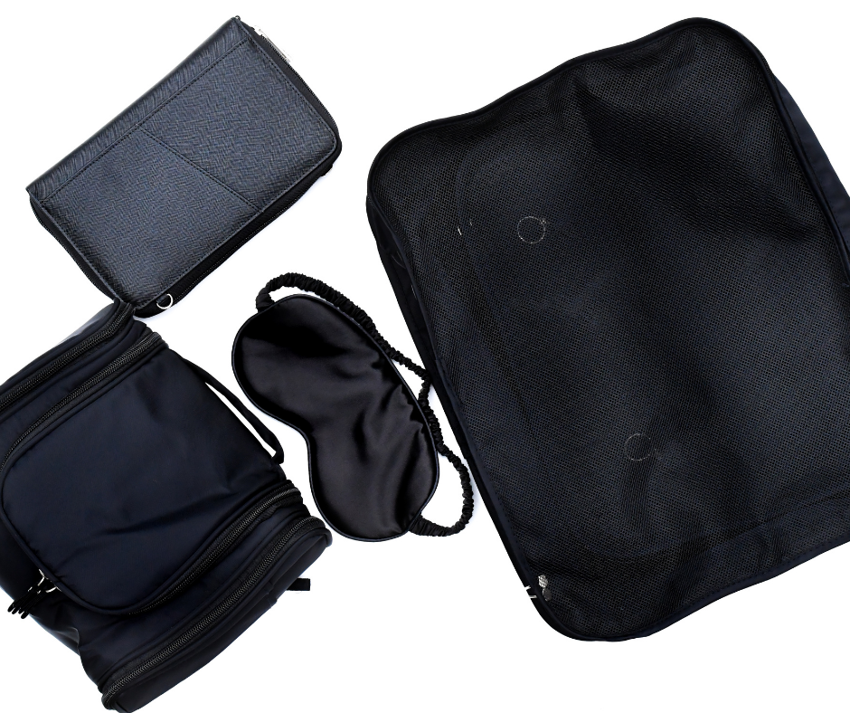 black cosmetic case, passport wallet, packing cubes and sleep mask on a white background