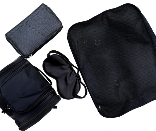 black cosmetic case, passport wallet, packing cubes and sleep mask on a white background