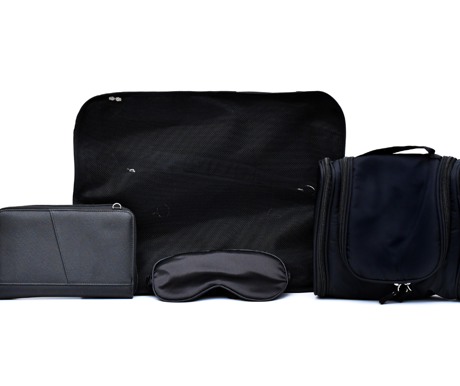 black cosmetic case, passport wallet, packing cubes and sleep mask on a white background