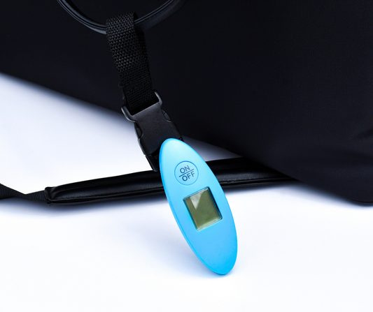 blue luggage scales attached to a black duffle bag handle on a white background